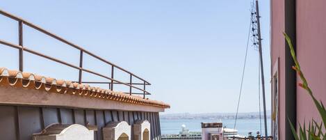Une vue sur la côte, avec un bâtiment doté d’un toit recouvert de tuiles et d’un balcon.