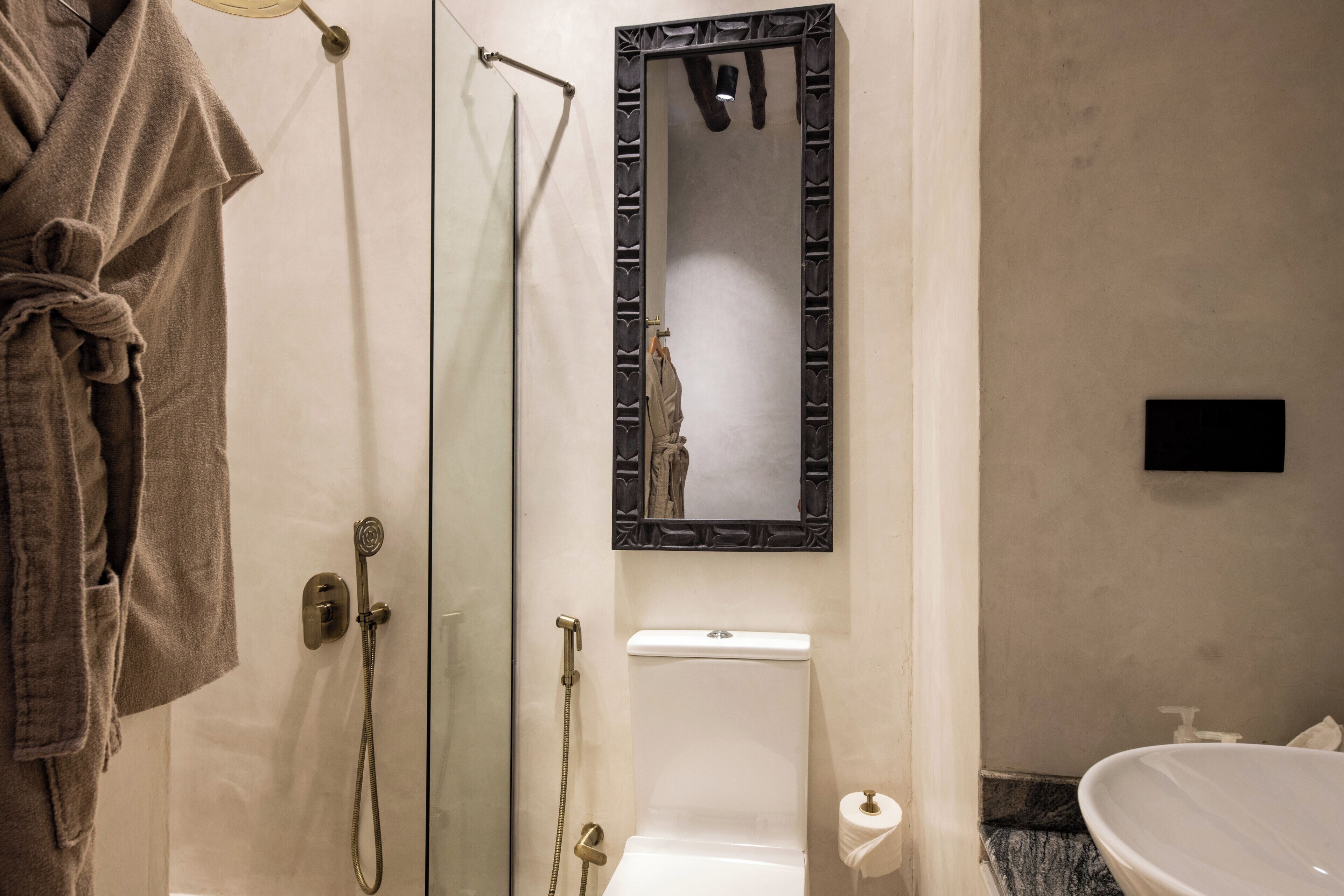 A bathroom with a glass-enclosed shower, a toilet, and a sink.