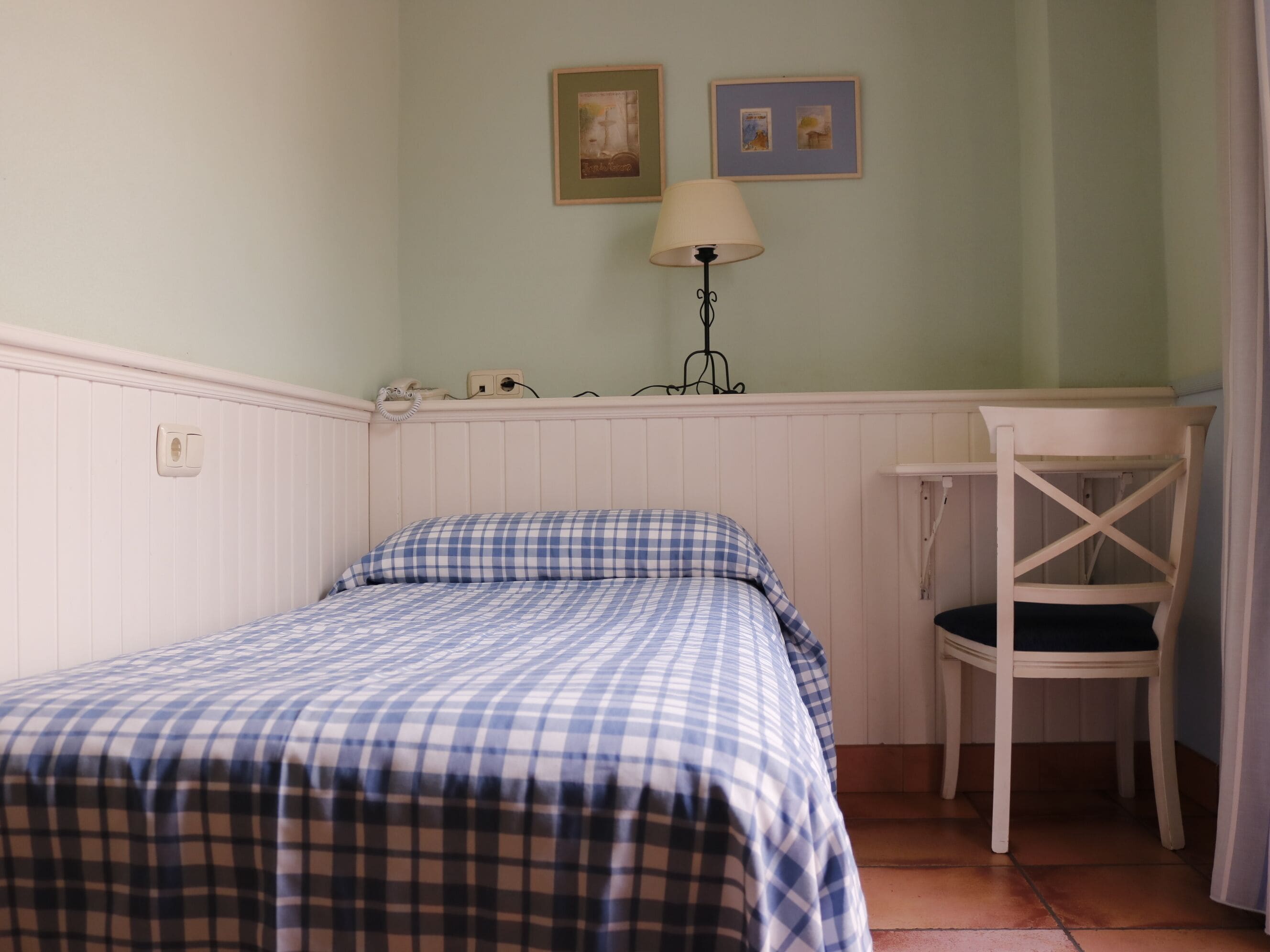 A room with a bed, a desk, and a chair.