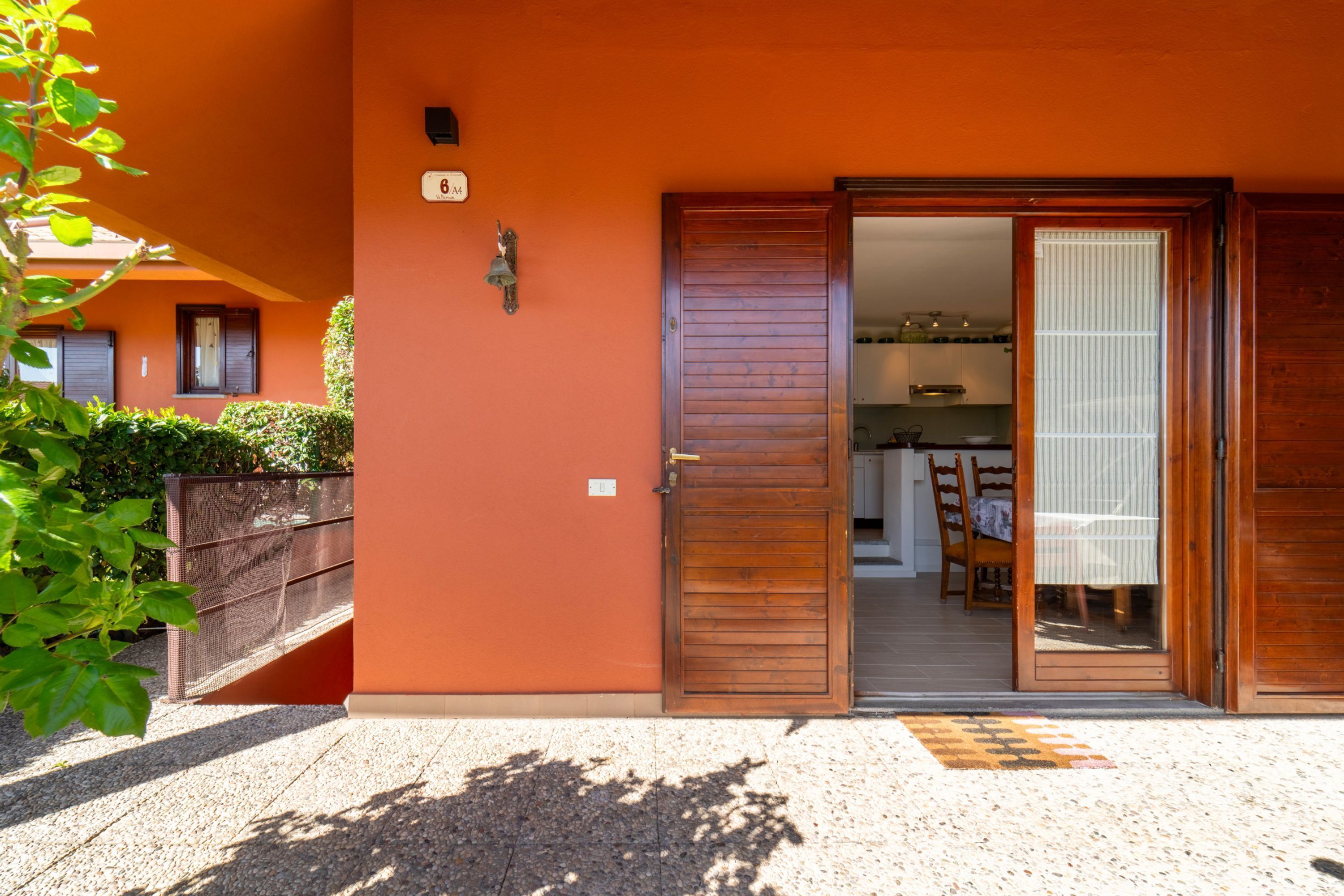 A building with a wooden door and a visible kitchen area.