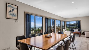 Une pièce spacieuse avec une grande table à manger, des sièges confortables et une vue sur l’océan.