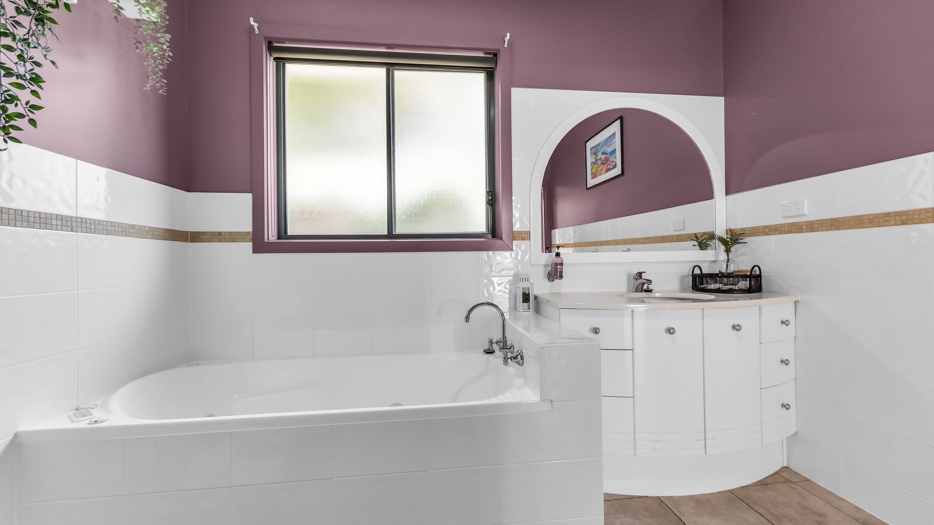 A bathroom with a bathtub, a sink, and a vanity with drawers.
