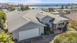 Une maison d’habitation avec un garage, une véranda et une vue sur l’océan.