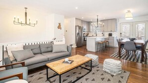Un salon moderne avec un canapé, une table basse et un tapis à motifs.