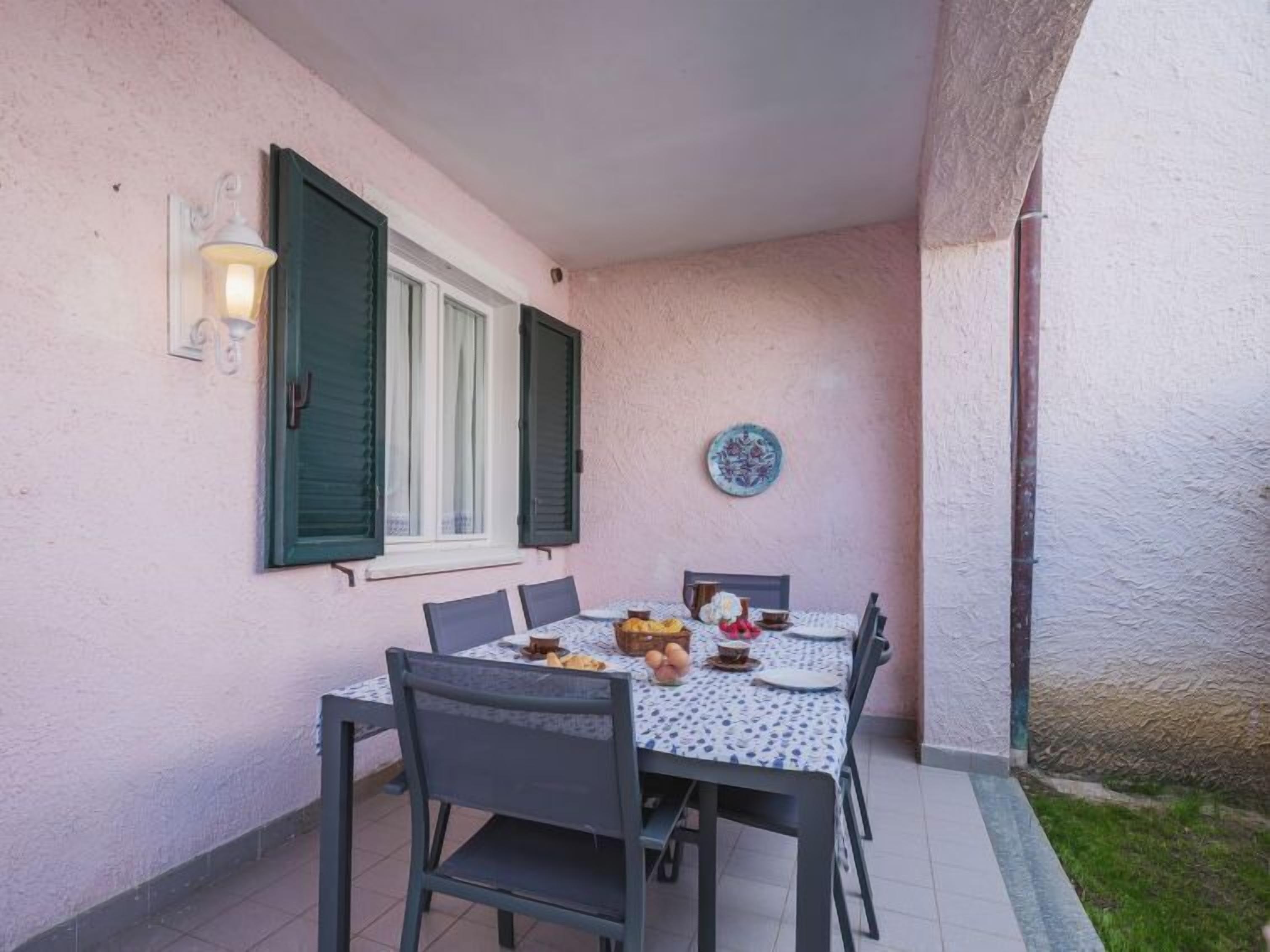 A dining area with a table and chairs, a wall-mounted light fixture, and a decorative plate.