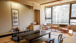 A traditional Japanese room with tatami flooring, a low table, and seating arrangements. - Hijiori Onsen Kangetsu (Okura)