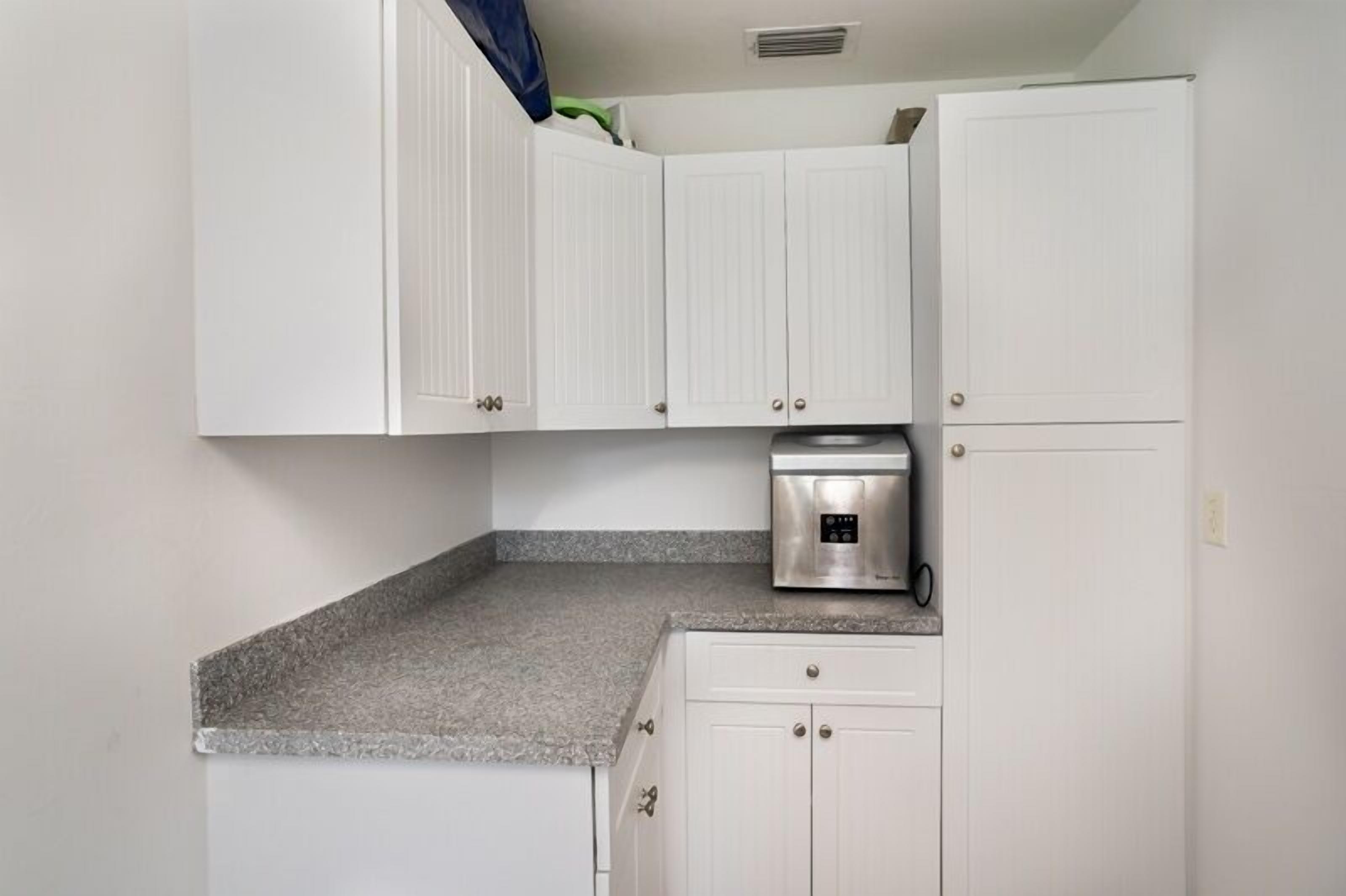A kitchen with white cabinets, a granite countertop, and a built-in oven.
