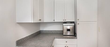 A kitchen with white cabinets, a granite countertop, and a built-in oven.
