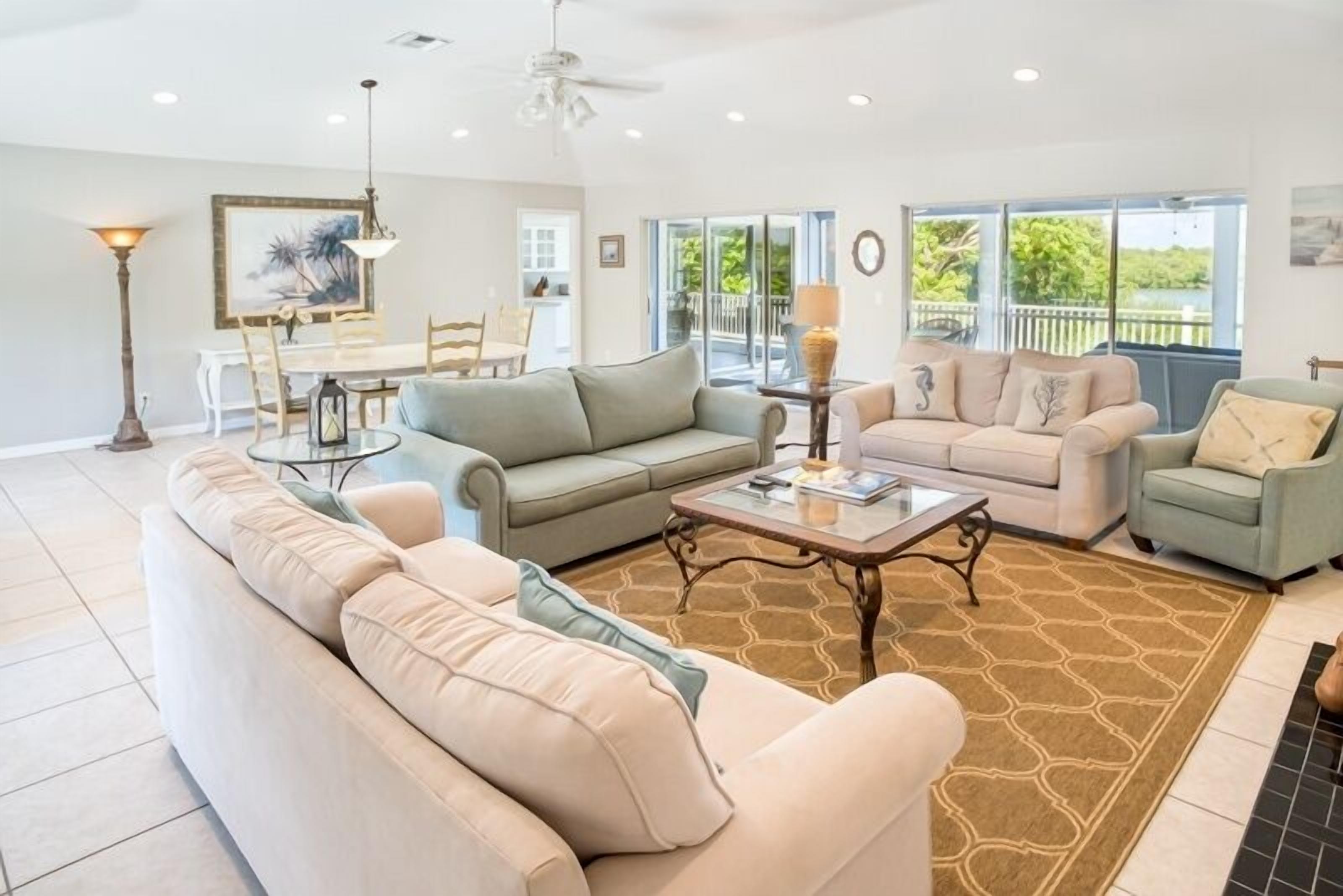 A spacious living room with a large sofa, a coffee table, and a dining area with a table and chairs.