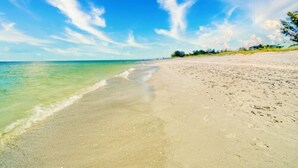 A beach with clear water and a sandy shore. - Little Current 3 Bedroom Home by RedAwning (Captiva)