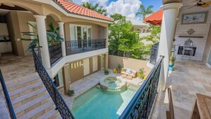 Ein mehrstufiges Außenareal mit Swimmingpool, Whirlpool und überdachter Sitzgruppe.