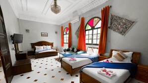 A hotel room with two beds, a TV, a desk, and a chandelier. - Hotel Riad Qodwa (Sidi Abdallah Ghiat)