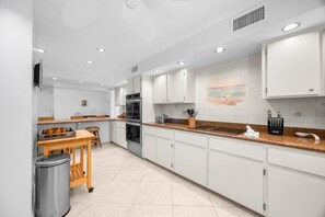 Eine moderne Küche mit weißen Schränken, einer Granitabdeckung und einem eingebauten Backofen.