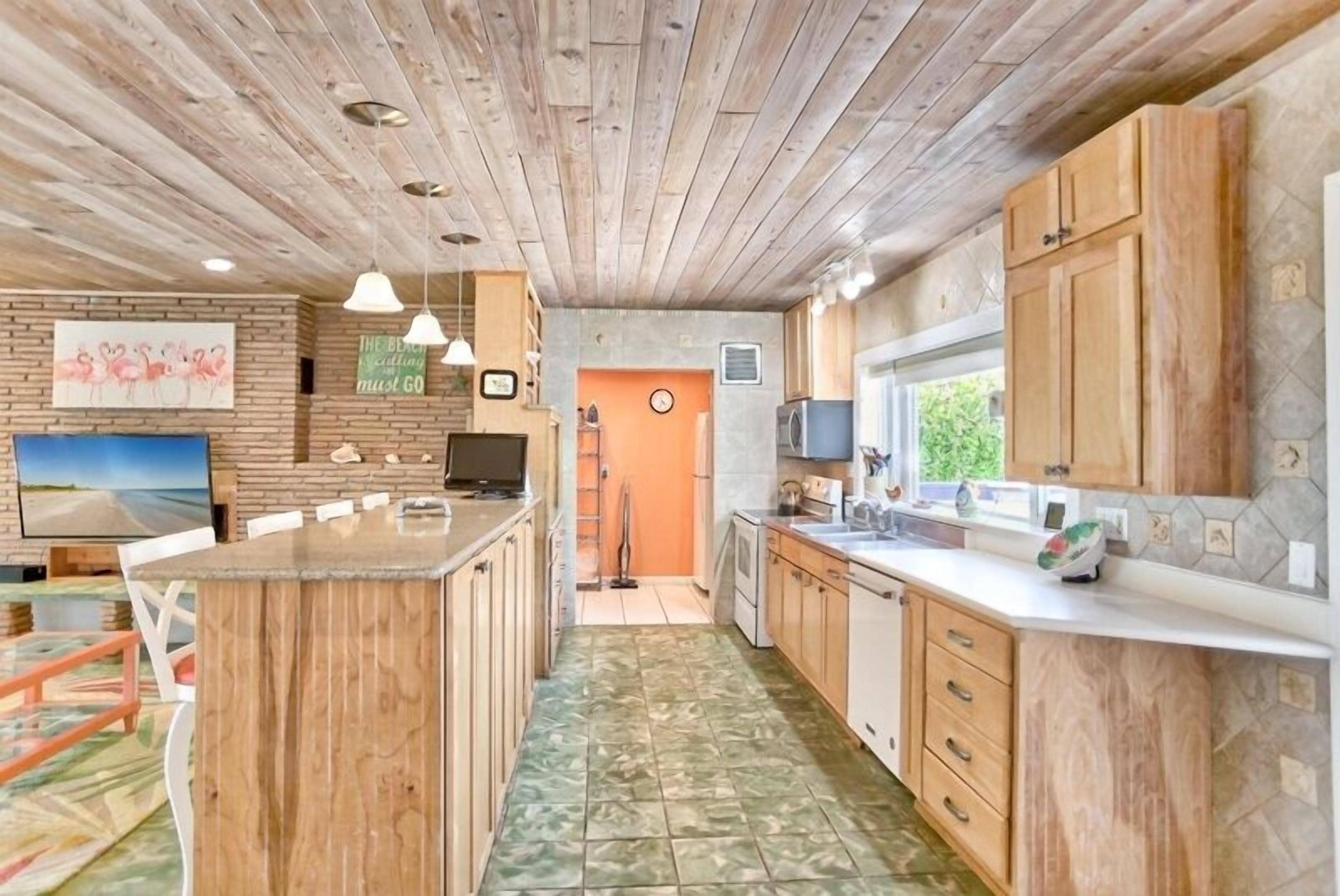 A kitchen with wooden cabinets, a central island, and a tiled floor.