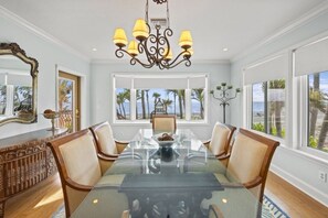 Enjoy meals in this dining area with a glass table and six chairs, surrounded by a stunning ocean view.