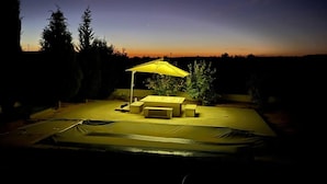 An outdoor patio area with a yellow umbrella, a table, and chairs. - Cheerful 2-bedroom Villa With Pool (Nasrallah)