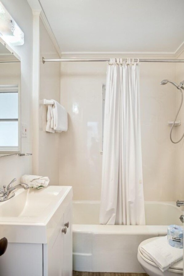 Un baño con bañera, lavamanos e inodoro.