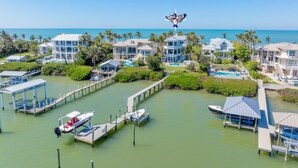 A marina with multiple boats docked, a pier, and several waterfront villas with a clear view of the ocean. - Captiva Grace 5 Bedroom Home by RedAwning (Captiva)
