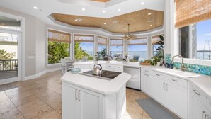 A spacious kitchen with a central island, large windows with views, and a wooden ceiling. - Captiva Grace 5 Bedroom Home by RedAwning (Captiva)