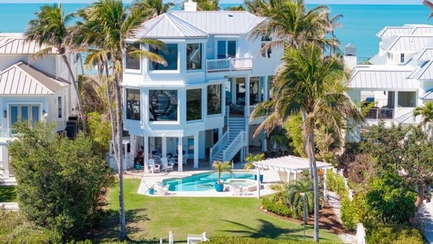 A large, multi-story house with a pool and a view of the ocean. - Captiva Grace 5 Bedroom Home by RedAwning (Captiva)