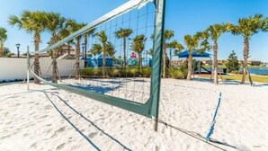 A beach volleyball net on a sandy court with palm trees in the background. - Lovely 5br Townhouse At Windsor At Westside 5 Bedroom Townhouse by RedAwning (Kissimmee)