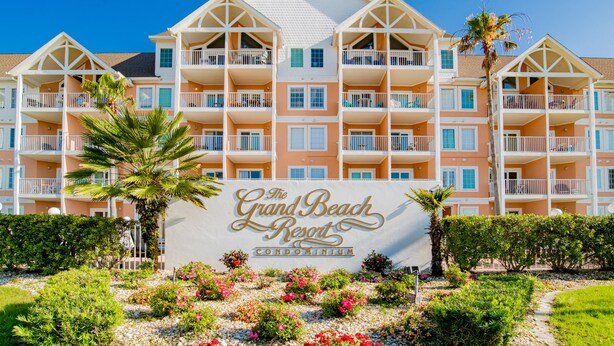 A multi-story building with balconies and a sign that reads "The Grand Beach Resort Condominium". - Grand Beach Resort #311 - Close to Beach with Gulf Views and Resort Amenities (Gulf Shores)