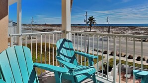 A balcony with turquoise Adirondack chairs, a palm tree, and a view of the beach and ocean. - Grand Beach Resort #311 - Close to Beach with Gulf Views and Resort Amenities (Gulf Shores)