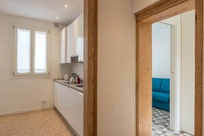 Una cucina con una finestra, un lavello e un piano di lavoro.