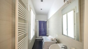A narrow bathroom with a white radiator, a large mirror, and a white sink. - Rialto al Manganer, apartment near Rialto Mercato (Venezia)
