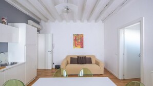 Ett kompakt bostadsutrymme med ett litet kök, en soffa och en matplats.