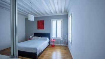 Una camera da letto con un letto, un comodino, una sedia e una finestra.