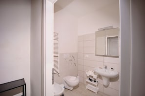 A small, clean bathroom with a toilet, sink, and towel rack.