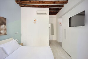 A hotel room with a bed, a wardrobe, a television, and an air conditioning unit. - La casetta di Foscolo (Venezia)