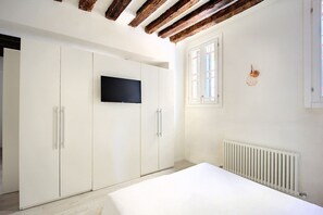A bedroom with a bed, a wardrobe, a television, a window, and a radiator. - La casetta di Foscolo  (Venezia)