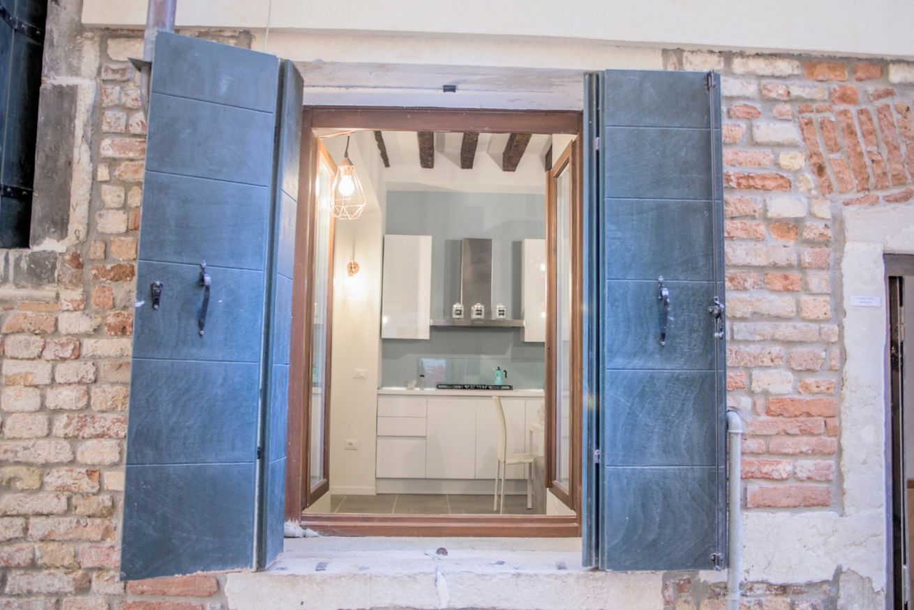 Une cuisine avec des meubles blancs et un plan de travail en bois.