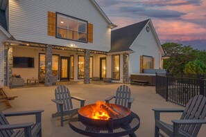 A house with a covered patio area featuring a fire pit, outdoor seating, and stone pillars. - Best view, near Hells Gate, pool/hot tub/game room (Strawn)