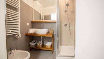 A modern bathroom with a sink, mirror, and shower.