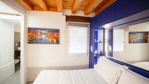 A bedroom with a large bed, a wooden ceiling, and two paintings of a cityscape. - Ca' Gritti, Castello next to Arsenale (Venezia)