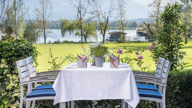 Une table dressée à l’extérieur, avec vue sur un lac et des montagnes.