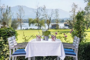 A table set outdoors with a view of a lake and mountains.