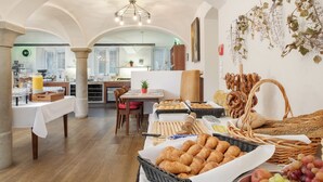 Un buffet de petit-déjeuner comprenant du pain, des viennoiseries et des fruits.