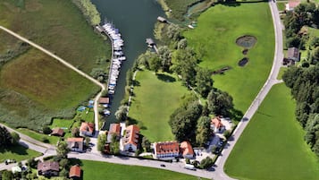 An aerial view of a lakeside property with a marina, green lawns, and residential buildings.
