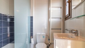 Une salle de bain équipée de toilettes, d’un bidet et d’un lavabo.