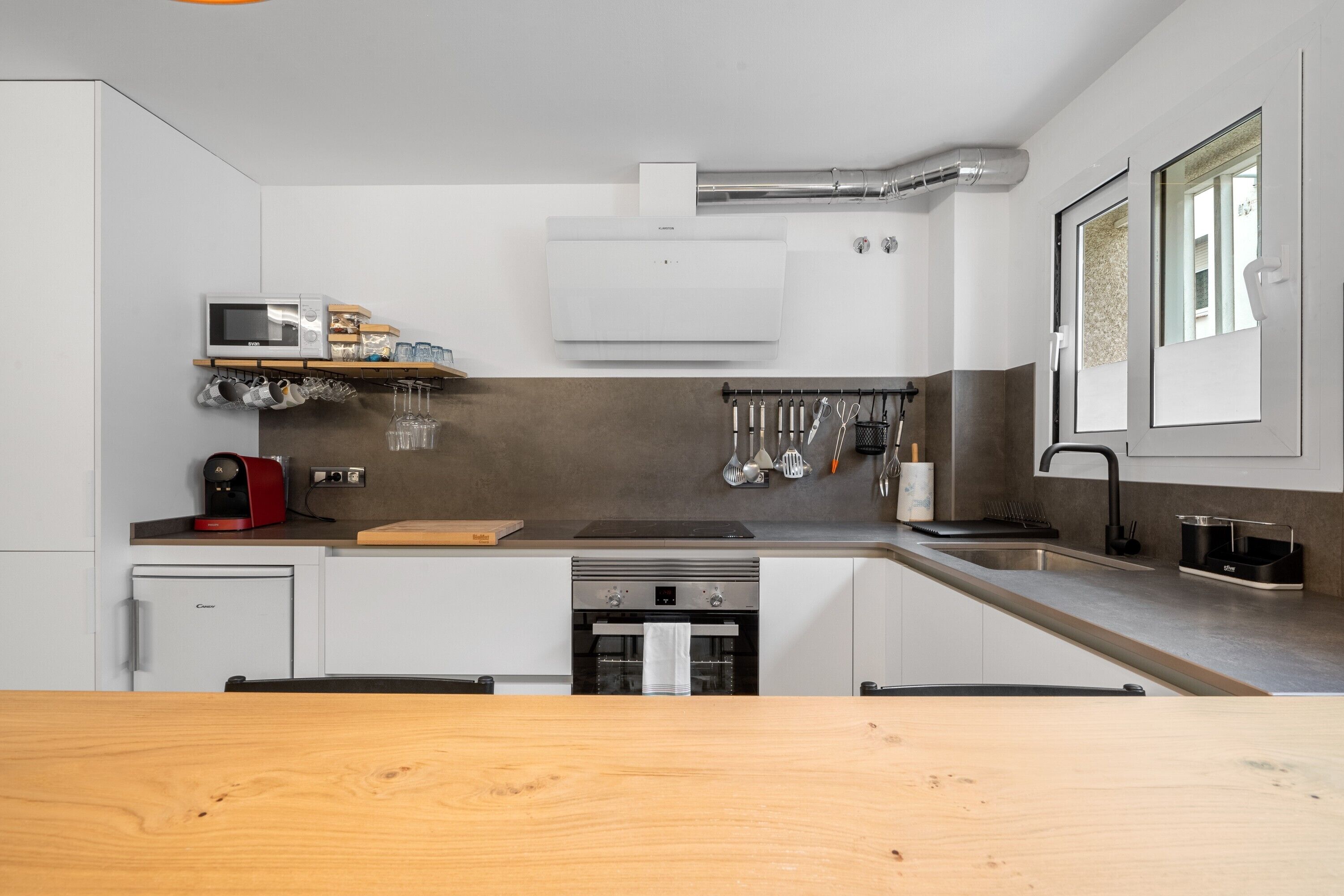 A modern kitchen with a microwave, oven, and sink.