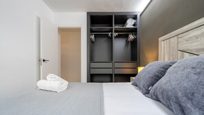 Ein Schlafzimmer mit einem Bett, einem Kleiderschrank und einer Tür.