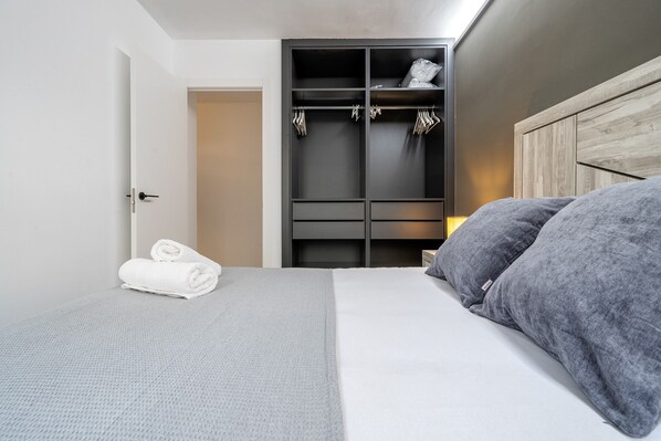 A bedroom with a bed, a wardrobe, and a door.
