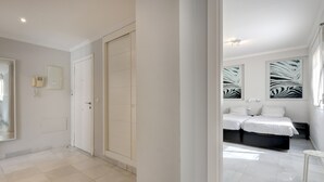 A modern bedroom with a large bed, a bedside table, and a wall-mounted telephone. - Apartment "Mirador de la Cala" with Terraces & Wi-Fi (Estepona)