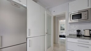 A modern kitchen with white cabinetry, a microwave, and a coffee maker. - Apartment "Mirador de la Cala" with Terraces & Wi-Fi (Estepona)