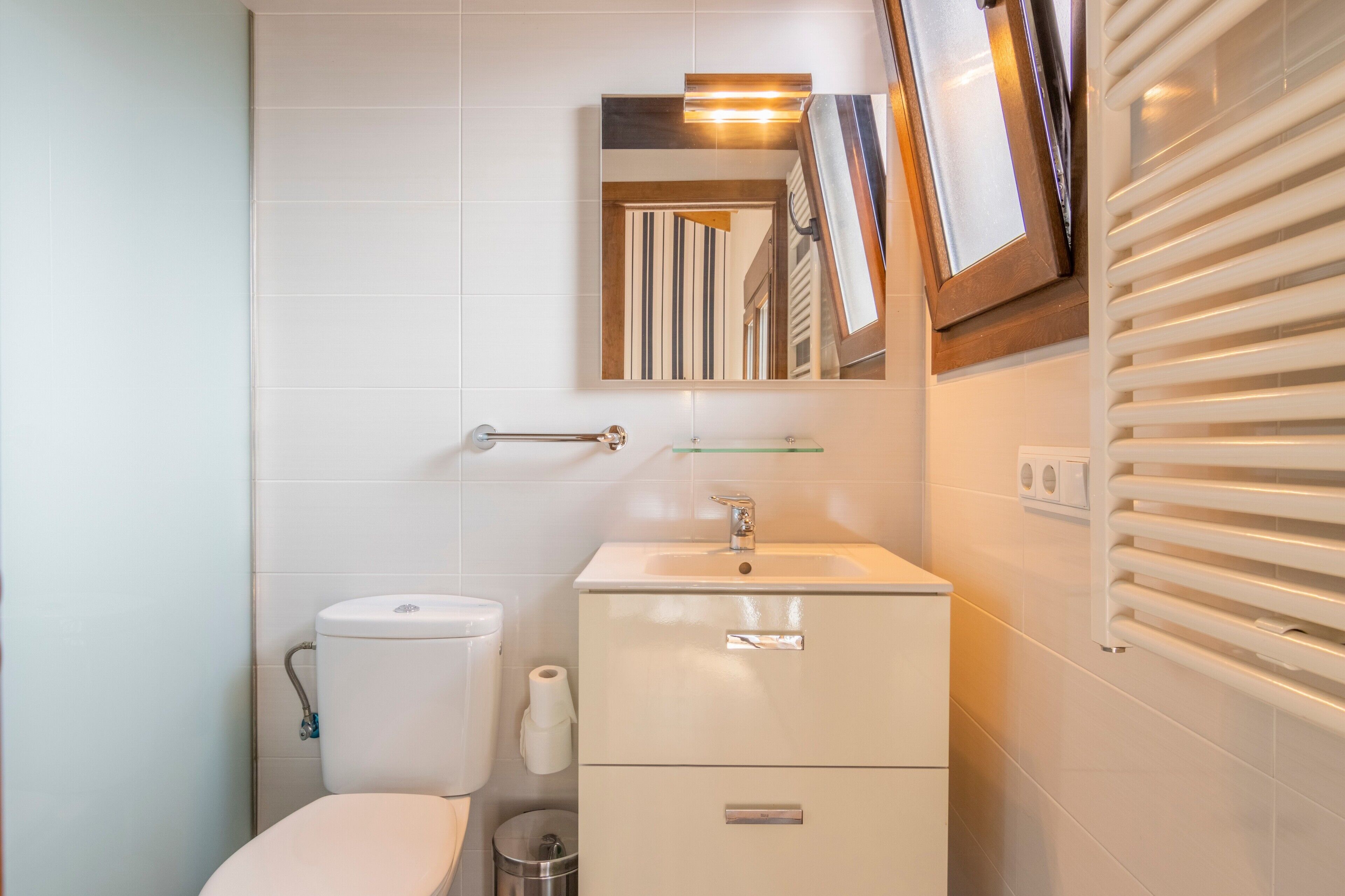 Ein Badezimmer mit Toilette, Waschbecken, Spiegel und Handtuchhalter.