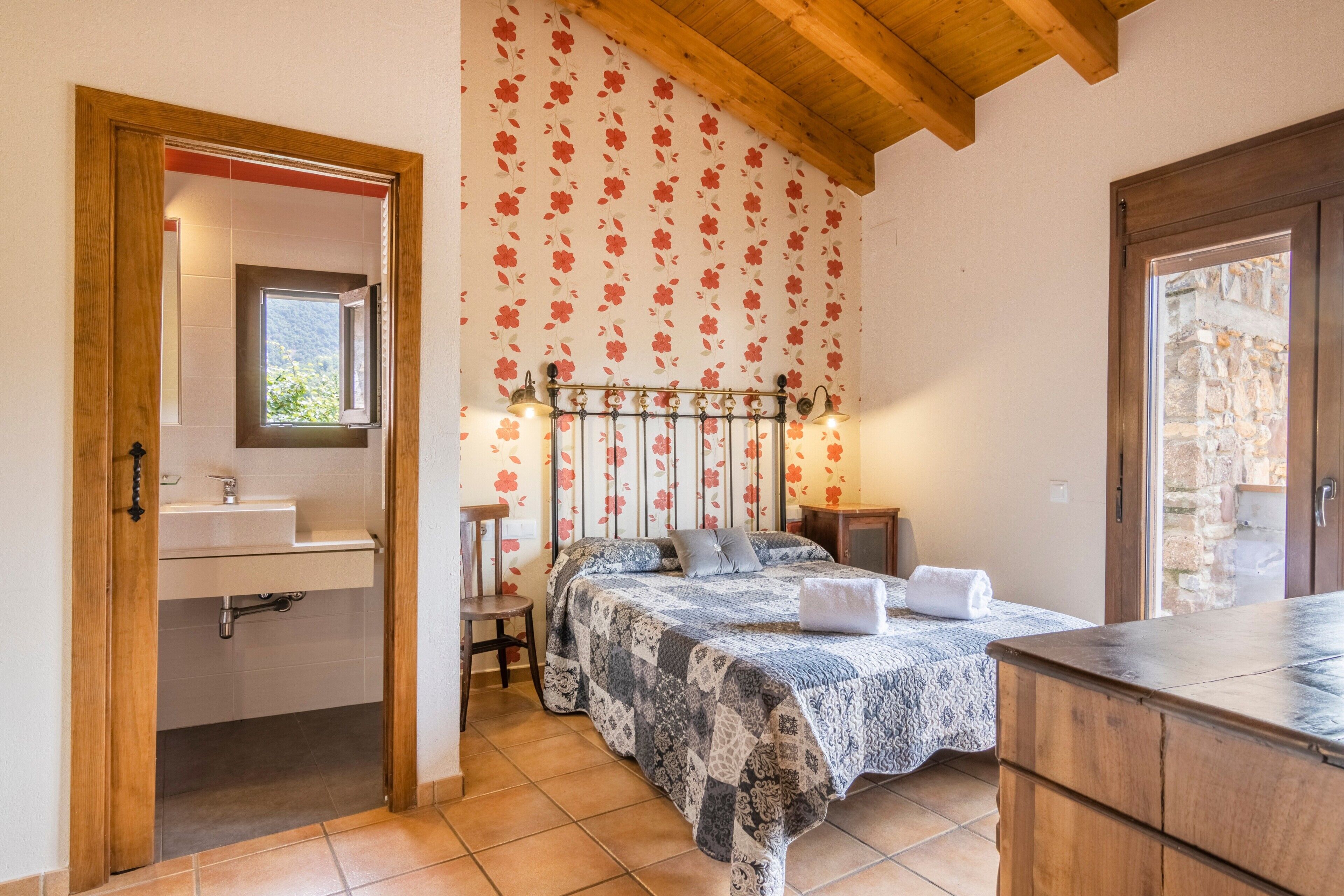 Un dormitorio con cama, mesita de noche y ventana.